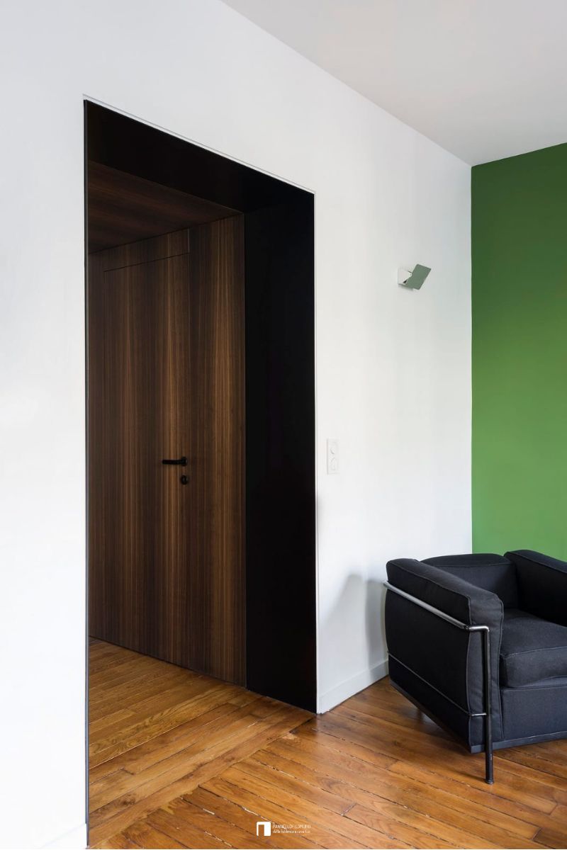 Porta battente filomuro con maniglia a cura del cliente e in finitura essenza di legno come la parete adiacente