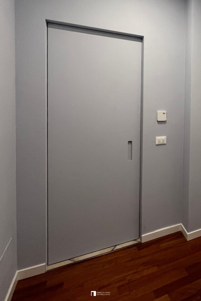 Porta battente filomuro standard con maniglia a incavo, le ante sono dipinte come la parete per il massimo effetto a scomparsa